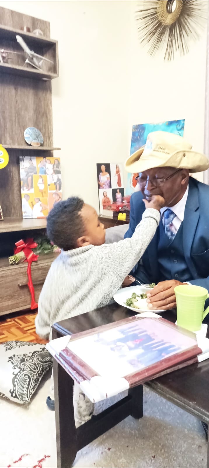 A grandchild's hand at the table — tenderness, always.